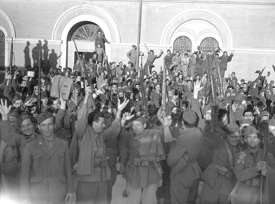 Soldati e lavoratori italiani applaudono alla notizia che l'Italia ha dichiarato guerra alla Germania, 24 ottobre 1943. (AP Photo/Bill Allen)