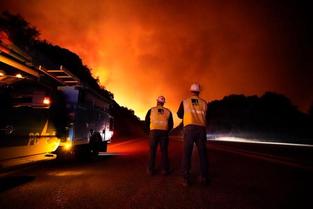 Pacific Gas and Electric workers stand along Highway 168 as the Creek Fire advances Tuesday, Sept. 8, 2020, near Alder Springs, Calif. (AP Photo/Marcio Jose Sanchez)