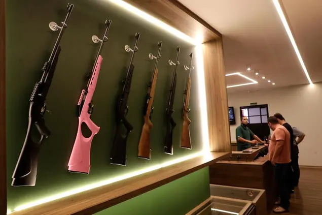 A pink, Brazilian-made CCB rifle marketed to women, is displayed with other weapons for sale at the Big Boar gun shop in Brasilia, Brazil, Thursday, March 4, 2021. (AP Photo/Eraldo Peres)