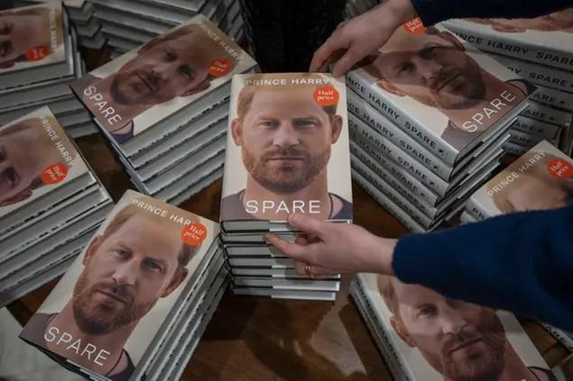 A member of staff places the copies of the new book by Prince Harry called \\\"Spare\\\" at a book store in London, Tuesday, Jan. 10, 2023. Prince Harry's memoir \\\"Spare\\\" went on sale in bookstores on Tuesday, providing a varied portrait of the Duke of Sussex and the royal family. (AP Photo/Kin Cheung)