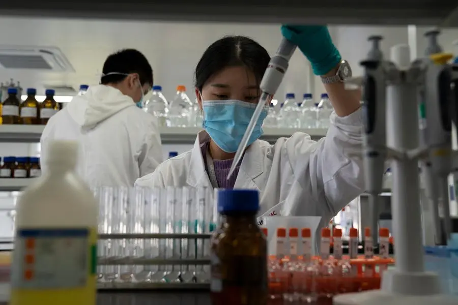 An employee of SinoVac works in a lab at a factory producing its SARS CoV-2 Vaccine for COVID-19 named CoronaVac in Beijing on Thursday, Sept. 24, 2020. SinoVac's CEO says they have injected 90 percent of its employees and family members, or about 3,000 people, and provided tens of thousands of rounds of CoronaVac to the municipal government of Beijing. It's a highly unusual move that raises ethical and safety questions, as companies and governments worldwide race to develop a vaccine that will stop the spread of the new coronavirus. (AP Photo/Ng Han Guan)