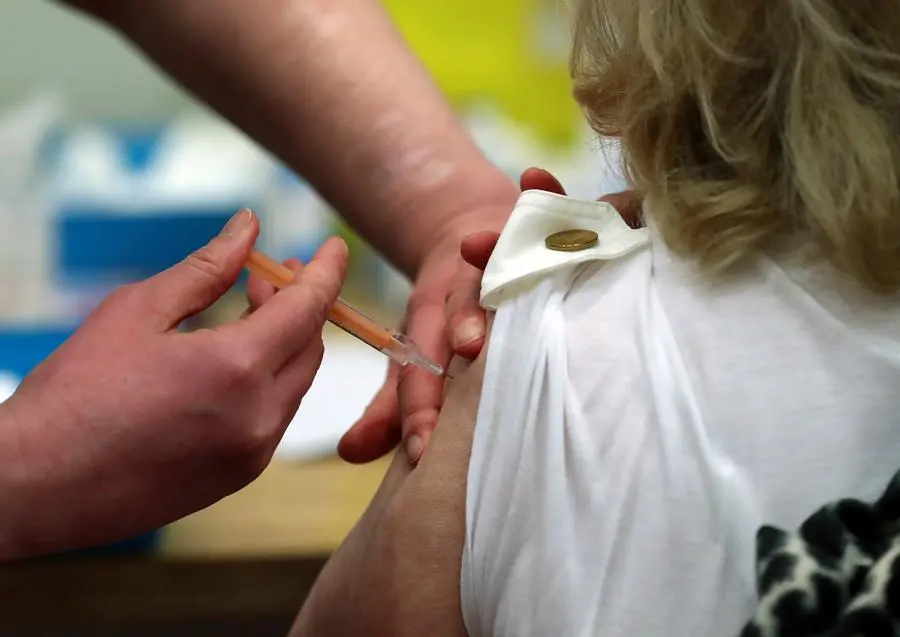 FILE - In this Jan. 11, 2021, file photo Mary Williams, right, receives an injection of the AstraZeneca vaccine at the mass vaccination centre in Newcastle Upon Tyne, England. In recent days, countries including Denmark, Ireland and Thailand have temporarily suspended their use of AstraZeneca's coronavirus vaccine after reports that some people who got a dose developed blood clots, even though there's no evidence that the shot was responsible. The European Medicines Agency and the World Health Organization say the data available do not suggest the vaccine caused the clots. Britain and several other countries have stuck with the vaccine. (AP Photo/Scott Heppell, File)