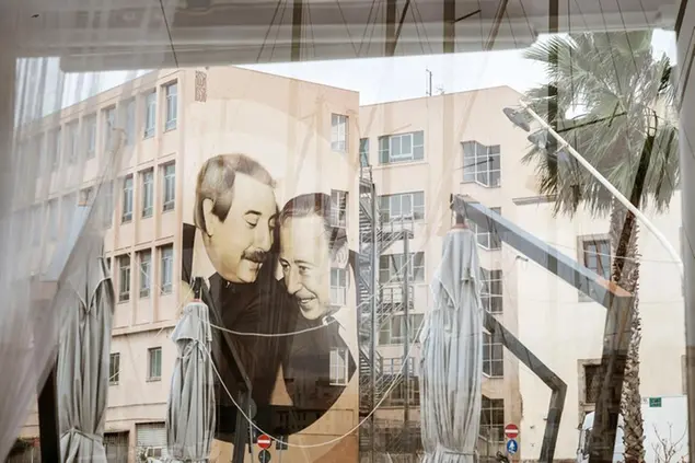 A mural by street artists Rosk e Loste, reproducing an iconic photo of top anti-mafia prosecutors Giovanni Falcone, left, and Paolo Borsellino, is seen on the side of a building in Palermo, Italy, Tuesday Jan. 17, 2023. Italy's No. 1 fugitive, Mafia boss Matteo Messina Denaro, was arrested Monday after 30 years on the run. He is set to be imprisoned for the two bombings in Sicily in 1992 that murdered the two top anti-Mafia prosecutors Falcone and Borsellino, and other grisly crimes. (AP Photo/Valeria Ferraro)