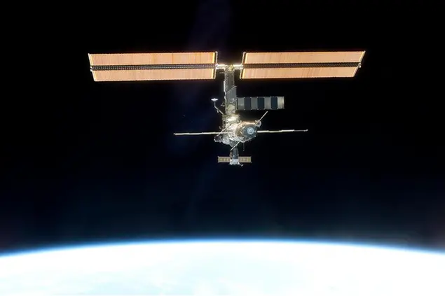 In this photo provided by NASA, the International Space Station, backdropped against black space above Earth's horizon, is seen from the Space Shuttle Discovery on March 19, 2001, after a new crew comprised of cosmonaut Yury Usachev and astronauts James Voss and Susan Helms began several months aboard the station. In the early days of the station, it was a cramped and humid, with just three rooms. It's much larger now, with six sleeping compartments, three toilets, a domed lookout and three high-tech labs. (NASA via AP)