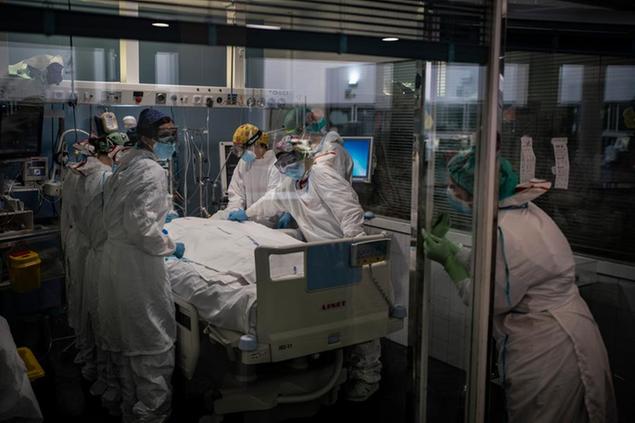 A COVID-19 patient receives treatment in the ICU of the Hospital del Mar, in Barcelona, Spain, Tuesday, Jan. 19, 2021. The unrelenting increase in COVID-19 infections in Spain following the holiday season is again straining hospitals, threatening the mental health of doctors and nurses who have been at the forefront of the pandemic for nearly a year. (AP Photo/Felipe Dana)