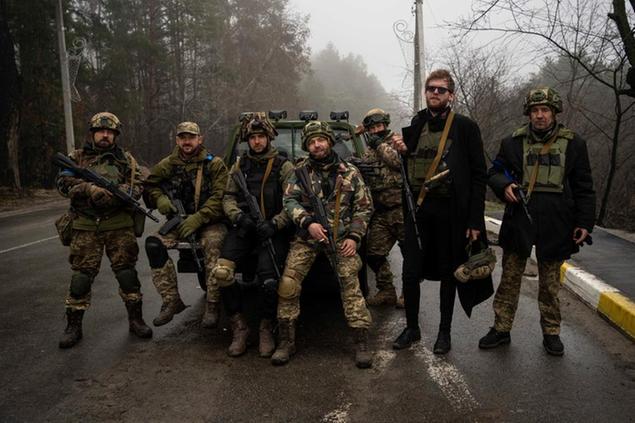 Kyiv region territorial defense unit pose for a picture after a military sweep to search for possible remnants of Russian troops after their withdrawal from villages in the outskirts of Kyiv, Ukraine, Friday, April 1, 2022. (AP Photo/Rodrigo Abd)