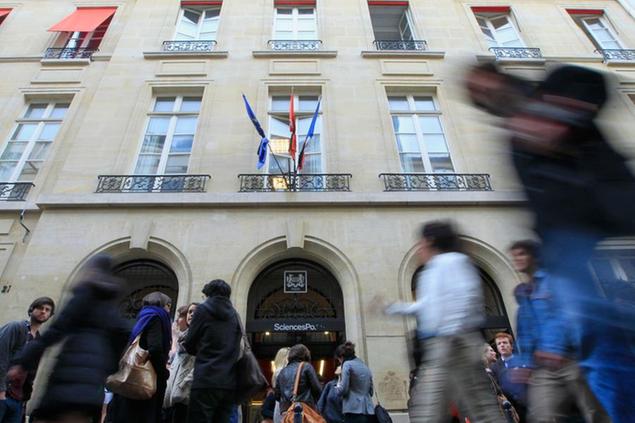 Students walk past in front of the entrance of the Institut d'etudes Politiques, or The Paris institute with French and European flags at half staff above, Wednesday, April 4, 2012. Richard Descoings, director of the institute, was found dead in a New York City hotel room, Tuesday afternoon, April 3, 2012. The Paris institute is better known in France as Sciences Po. It's considered a training ground for France's political, media and administrative elite. (AP Photo/Jacques Brinon)