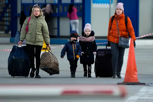Refugees leaving to Romania after fleeing from Ukraine, walk at the border crossing in Palanca, Moldova, Thursday, March 17, 2022. (AP Photo/Sergei Grits)