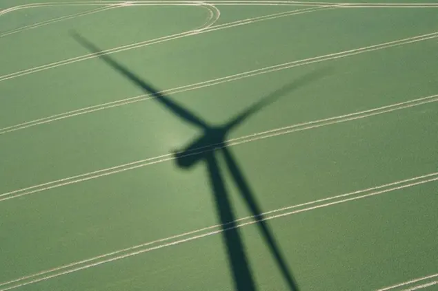 26 April 2022, Schleswig-Holstein, Sehestedt: A wind turbine at the Sehestedt wind farm casts a shadow on a field. Photo by: Marcus Brandt/picture-alliance/dpa/AP Images