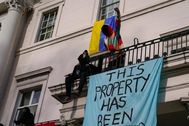 Squatters display banners and a Ukrainian flag as they occupy a building which is believed to be owned by a Russian oligarch, in London, Monday, March 14, 2022.(AP Photo/Alberto Pezzali)
