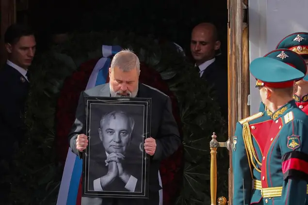Nobel Peace Prize awarded journalist Dmitry Muratov carries a portrait of the late former Soviet president Mikhail Gorbachev after a farewell ceremony at the Pillar Hall of the House of the Unions in Moscow, Saturday, Sept. 3, 2022. (Maxim Shipenkov/Pool Photo via AP)