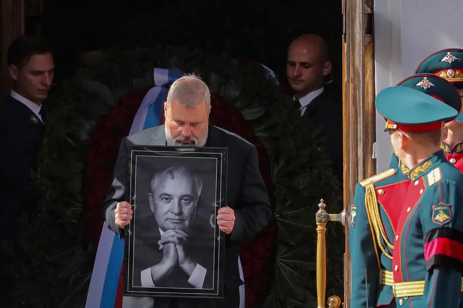 Nobel Peace Prize awarded journalist Dmitry Muratov carries a portrait of the late former Soviet president Mikhail Gorbachev after a farewell ceremony at the Pillar Hall of the House of the Unions in Moscow, Saturday, Sept. 3, 2022. (Maxim Shipenkov/Pool Photo via AP)