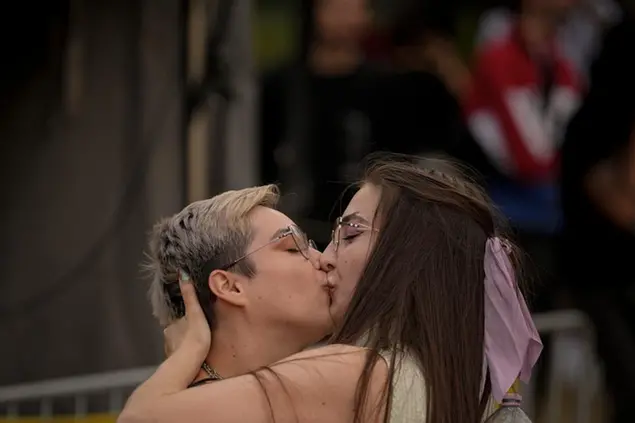 Girls kiss during the gay pride parade in Bucharest, Romania, Saturday, July 9, 2022. Thousands attended the gay pride march in the Romanian capital calling for legal rights for gays, like civil partnership, marriage or the right to adopt a child. (AP Photo/Andreea Alexandru)