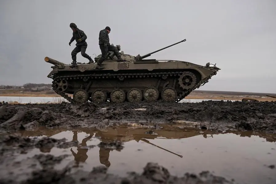 Ukrainian servicemen walk on an armored fighting vehicle during an exercise in a Joint Forces Operation controlled area in the Donetsk region, eastern Ukraine, Thursday, Feb. 10, 2022. A peace agreement for the separatist conflict in eastern Ukraine that has never quite ended is back in the spotlight amid a Russian military buildup near the country's borders and rising tensions about whether Moscow will invade.(AP Photo/Vadim Ghirda)