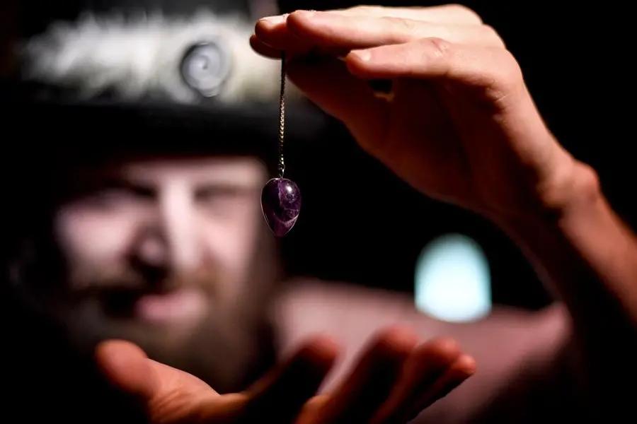 24 April 2019, Berlin: The actor Alex van Ric (as medium) holds a pendulum in his hand in the Berlin Dungeon. The show \\\"S'ance - Do you feel her too?\\\" is about a medium that tries to conjure up the spirit of a woman during a necromancy. Photo by: Britta Pedersen/picture-alliance/dpa/AP Images