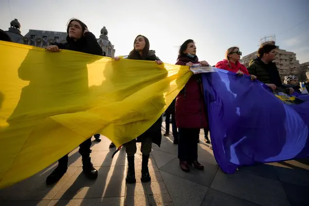 People hold a large Ukrainian flag during a protest against Russia's war in Ukraine, in Bucharest, Romania, Sunday, March 20, 2022. (AP Photo/Andreea Alexandru)