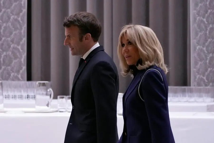 French President Emmanuel Macron, left, and his wife Brigitte Macron arrive to deliver a speech at a ceremony to honor 28 French medal-winning athletes at the Winter Olympics and Paralympics, in Paris, Tuesday, March 29, 2022. (AP Photo/Francois Mori, Pool)