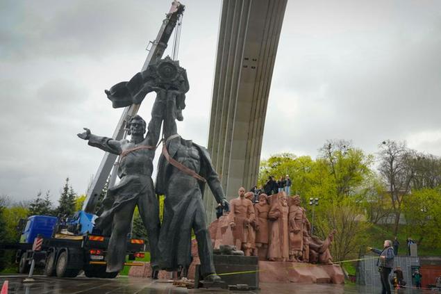 A Soviet era monument to a friendship between Ukrainian and Russian nations is seen during its demolition, amid Russia's invasion of Ukraine, in central Kyiv, Ukraine, Tuesday, April 26, 2022. (AP Photo/Efrem Lukatsky)