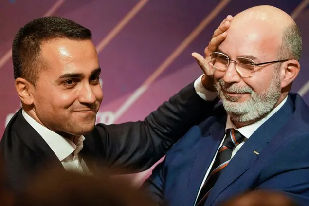 Italy's Foreign Minister and 5-Star Movement leader Luigi Di Maio, left, embraces his successor Vito Crimi at a meeting in Rome, Wednesday, Jan. 22, 2020, where Di Maio stepped down as party leader following a string of parliamentary defections, falling poll numbers and questions about the movement's future. Luigi Di Maio said he had finished his work, that an era had ended, and that he would trust his successor to lead the party going forward. (AP Photo/Andrew Medichini)