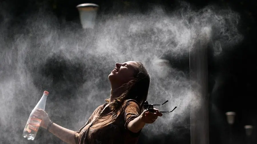 Una persona si siede in un'area fresca durante un'ondata di calore, con un'atmosfera calda e un'immagine di salute mentale in discussione