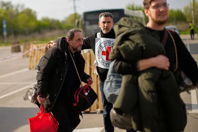 Serhii Tsybulchenko, left, and his son-in-law Ihor Trotsak, right, who fled with their family from the Azovstal steel plant in Mariupol, arrive to a reception center for displaced people in Zaporizhzhia, Ukraine, Tuesday, May 3, 2022. The Tsybulchenko family was among the first to emerge from the steel plant in a tense, days-long evacuation negotiated by the United Nations and the International Committee of the Red Cross with the governments of Russia, which now controls Mariupol, and Ukraine, which wants the city back. A brief cease-fire allowed more than 100 civilians to flee the plant. (AP Photo/Francisco Seco)