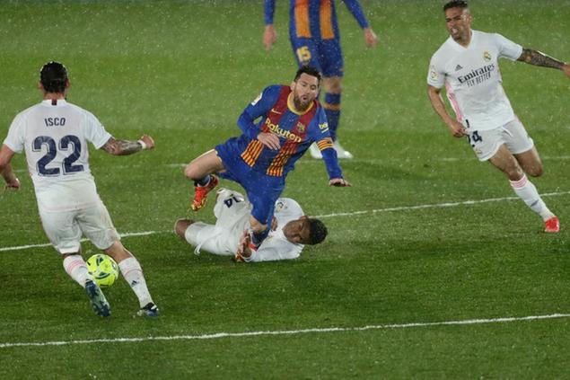 Barcelona's Lionel Messi, center top, is tackled by Real Madrid's Casemiro during the Spanish La Liga soccer match between Real Madrid and FC Barcelona at the Alfredo di Stefano stadium in Madrid, Spain, Saturday, April 10, 2021. Real Madrid won 2-1. (AP Photo/Manu Fernandez)
