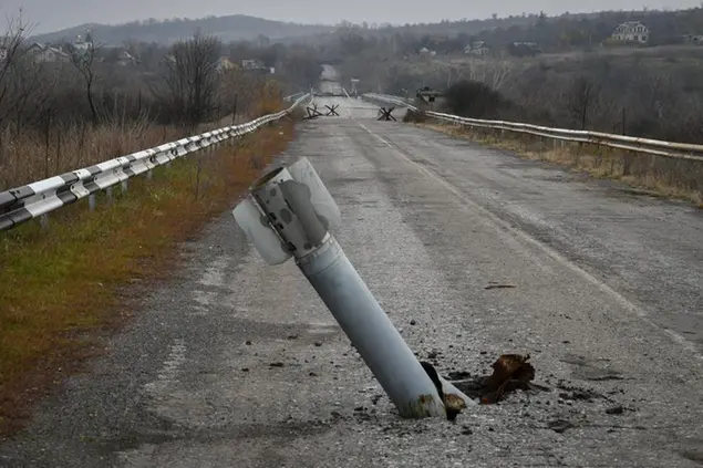 A tail of a multiple rocket sticks out of the ground near the recently recaptured village of Zakitne, Ukraine, Wednesday, Nov. 9, 2022. Villages and towns in Ukraine saw more heavy fighting and shelling Wednesday as Ukrainian and Russian forces strained to advance on different fronts after more than 8 1/2 months of war. At least nine civilians were killed and 24 others were wounded in 24 hours, the Ukrainian president's office said. (AP Photo/Andriy Andriyenko)
