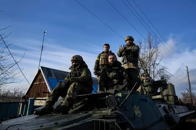 Ukrainian soldiers ride atop an armored vehicle near Bakhmut, Donetsk region, Ukraine, Thursday, Dec. 22, 2022. (AP Photo/Libkos)