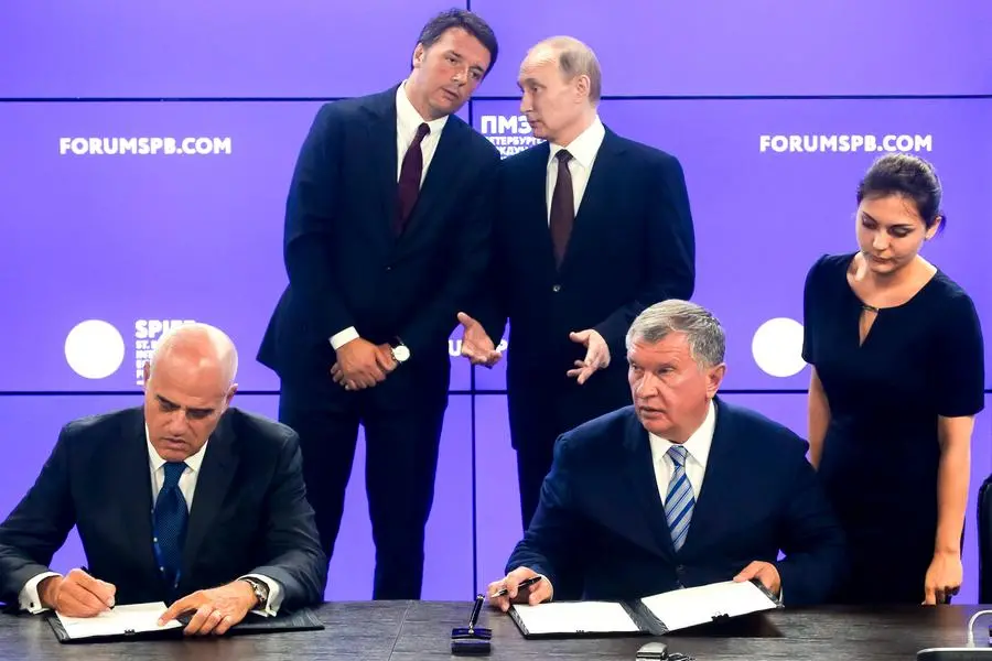Russian President Vladimir Putin, right back, and Italian Premier Matteo Renzi speak as CEO of state-controlled Russian oil company Rosneft Igor Sechin and CEO of Italian oil giant Eni Claudio Descalzi, left, sign documents during a signing ceremony at the St. Petersburg International Economic Forum in St. Petersburg, Russia, Friday, June 17, 2016. (AP Photo/Dmitry Lovetsky)