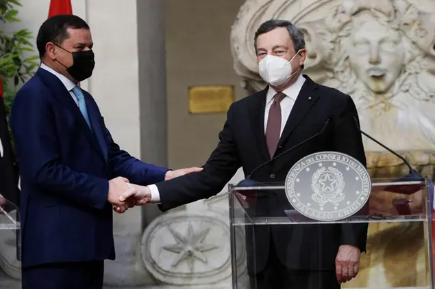 Italian Prime Minister Mario Draghi, right, and Libyan Prime Minister Abdulhamid Dbeibeh shake hands at the end of their meeting at Chigi palace, Premier's office, in Rome, Monday, May 31, 2021. (AP Photo/Gregorio Borgia, Pool)