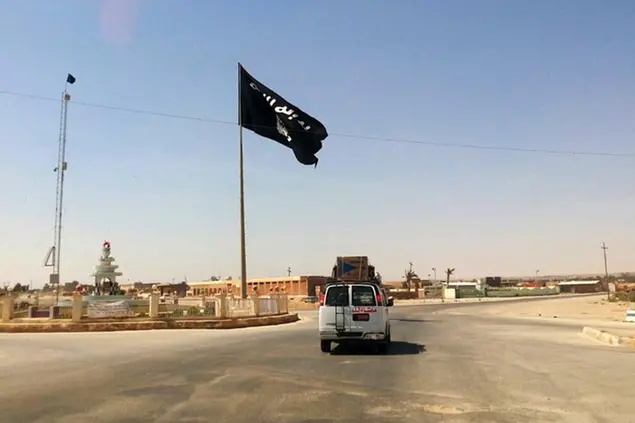 FILE - A motorist passes by a flag of the Islamic State group in central Rawah, 175 miles (281 kilometers) northwest of Baghdad, Iraq, July 22, 2014. Members of the global coalition fighting the Islamic State group are meeting in Morocco on Wednesday May 11, 20222 to discuss ongoing efforts in the campaign. The meeting is a reminder of the persistent threat from the extremist group despite the overwhelming preoccupation with Russiaâ€™s war on Ukraine. (AP Photo, File)