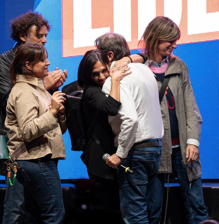 Sigfrido Ranucci e Giulia Presutti in un abbraccio durante una manifestazione, con didascalia "L'abbraccio di Giuda"