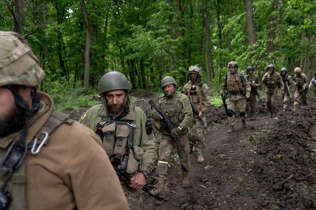 Ukrainian servicemen walk in the forest near a recently retaken village, north of Kharkiv, east Ukraine, Sunday, May 15, 2022. (AP Photo/Mstyslav Chernov)