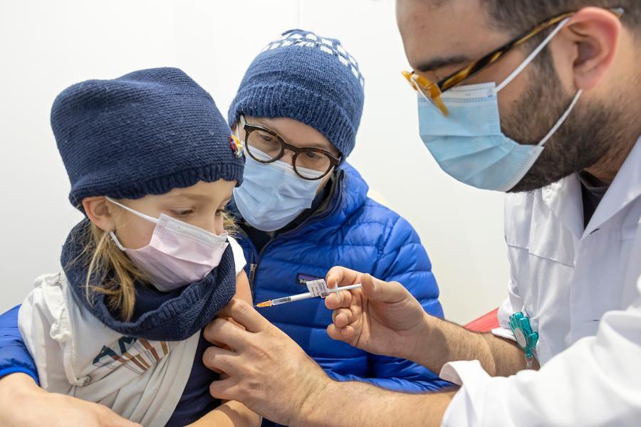 Alexandra, 5 year-old, receives a dose of the COVID-19 Pfizer vaccine at the vaccination center of the Geneva University Hospitals (HUG), in Geneva, Switzerland, Wednesday, January 5, 2022. French part of Switzerland started vaccinating children aged between five and eleven. (Salvatore Di Nolfi/Keystone via AP)