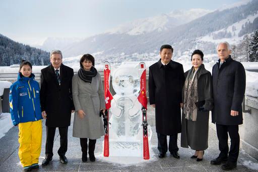 From left to right, Shuyao Song, chinese skiing teacher in the ski resort of Davos, Doris Leuthard's husband Roland Hausin, Swiss Federal President Doris Leuthard, China's President Xi Jinping, Xi's wife Peng Liyuan and Tarzisius Caviezel, Mayor of Davos, pose as they launch the Swiss-Sino year of tourism next to a panda ice sculpture on the side line of the 47th annual meeting of the World Economic Forum, WEF, in Davos, Switzerland, Tuesday, Jan. 17, 2017. (Laurent Gillieron/pool photo via AP)