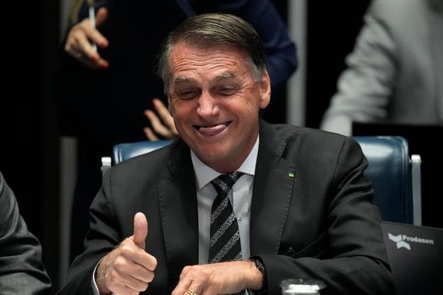 Brazil's President Jair Bolsonaro, who is running for a second term, reacts during the National Congress ceremony for the promulgation of constitutional amendments approved by parliament, in Brasilia, Brazil, Thursday, July 14, 2022. Lawmakers voted to declare a state of emergency that waives a constitutional cap on government spending. (AP Photo/Eraldo Peres)