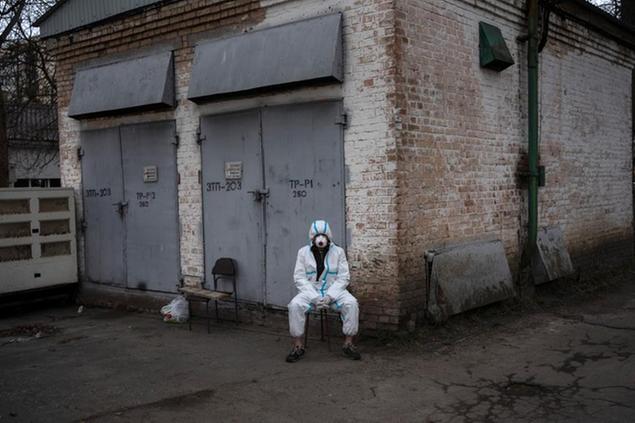 A volunteer rests after loading into a truck a plastic bags that contains the corpses of civilians killed by Russian soldiers, in Bucha, in the outskirts of Kyiv, Ukraine, Tuesday, April 12, 2022. (AP Photo/Rodrigo Abd)