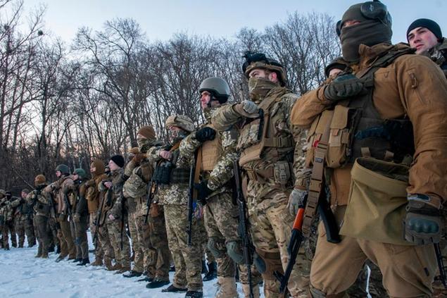 Ukrainian servicemen gesture during a training session outside Kharkiv, Ukraine, Friday, March 11, 2022. (AP Photo/Andrew Marienko)