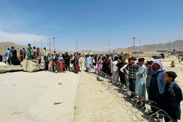 (Centinaia di persone si sono messe in fila per accedere all’aeroporto internazionale di Kabul e poter così fuggire dai talebani.\\u00A0Foto AP)