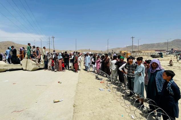 (Centinaia di persone si sono messe in fila per accedere all\\u2019aeroporto internazionale di Kabul e poter cos\\u00EC fuggire dai talebani.\\u00A0Foto AP)