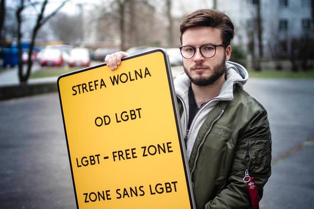 (L'attivista lgbt Bart Staszewski usa un cartello per protestare contro le lgbt free zones in Polonia. Foto AP)
