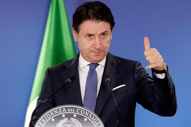 Italy's Prime Minister Giuseppe Conte addresses a media conference at an EU summit in Brussels, Friday, Dec. 11, 2020. European Union leaders have reached a hard-fought deal to cut the bloc's greenhouse gas emissions by at least 55 percent by the end of the decade compared with 1990 levels, avoiding a hugely embarrassing deadlock ahead of a U.N. climate meeting this weekend. (Olivier Hoslet, Pool via AP)