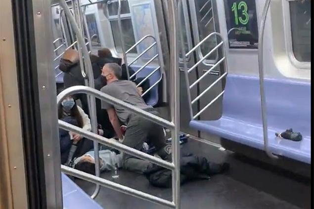 This photo provided by Will B Wylde, a person is aided in a subway car in the Brooklyn borough of New York, Tuesday, April 12, 2022. A gunman filled a rush-hour subway train with smoke and shot multiple people Tuesday, leaving wounded commuters bleeding on a Brooklyn platform as others ran screaming, authorities said. Police were still searching for the suspect. (Will B Wylde via AP)