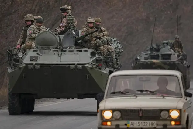 Ukrainian servicemen sit atop armored personnel carriers driving on a road in the Donetsk region, eastern Ukraine, Thursday, Feb. 24, 2022. Russian President Vladimir Putin on Thursday announced a military operation in Ukraine and warned other countries that any attempt to interfere with the Russian action would lead to \\\"consequences you have never seen.\\\" (AP Photo/Vadim Ghirda)