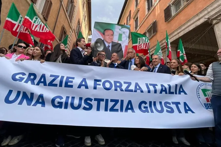 Una gigantografia di Silvio Berlusconi e attorno le bandiere di Forza Italia, durante il flash mob di Forza Italia per celebrare l'approvazione definitiva della riforma sulla separazione delle carriere dei magistrati, subito dopo il voto al Senato, in piazza Navona, a Roma