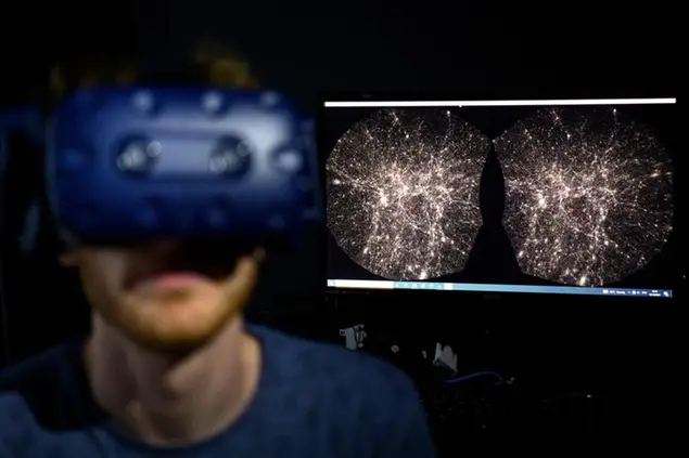FILE - In this Oct. 12, 2021 file photo, Hadrien Gurnel, software engineer EPFL's Laboratory for Experimental Museology (eM+) explores with a virtual reality helmet the most detailed 3D map of the universe with the virtual reality software VIRUP, Virtual Reality Universe Project developed by Swiss Federal Institute of Technology, in St-Sulpice near Lausanne, Switzerland. The term metaverse seems to be everywhere. Facebook is hiring thousands of engineers in Europe to work on it, while video game companies are outlining their long-term visions for what some consider the next big thing on the internet. Essentially, itâ€™s a world of endless, interconnected virtual communities where people can meet, work and play. You can go to a virtual concert, take a trip online and try on digital clothing. But tech companies still have to figure out how to connect their online platforms.(Laurent Gillieron/Keystone via AP)