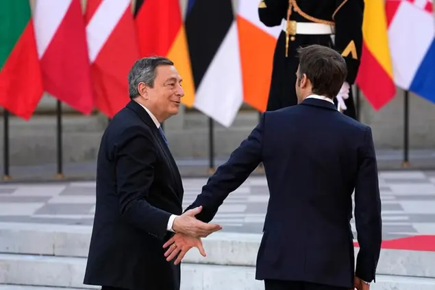 French President Emmanuel Macron, right, greets Italy's Prime Minister Mario Draghi during arrivals for an EU summit at the Chateau de Versailles, in Versailles, west of Paris, Thursday, March 10, 2022. European Union leaders on Thursday will focus on how to help Ukraine in its war with Russia, but the measures discussed are expected to stop short of fulfilling the country's hopes it can soon join the bloc. (AP Photo/Michel Euler)
