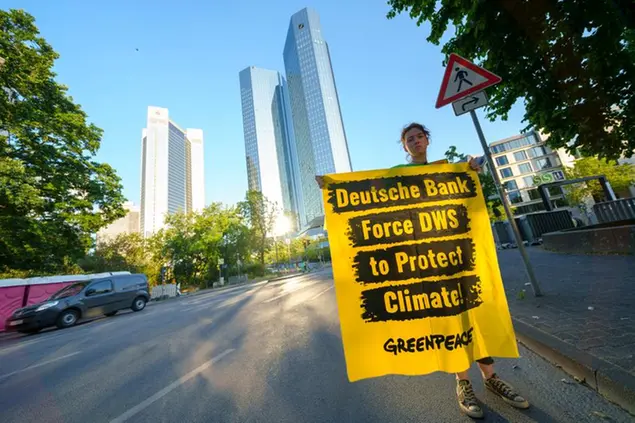 Protesta di Greenpeace davanti alle torri di Deutsche Bank a giugno 2023. Il cartello recita: \\\"Deutsche Bank, obbliga Dws a proteggere il clima!\\\"\\u00A0Foto AP