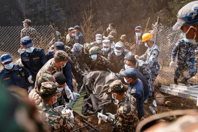 Rescue workers recover the body of a victim of a passenger plane that crashed in Pokhara, Nepal, Sunday, Jan. 15, 2023. A plane making a 27-minute flight to a Nepal tourist town crashed into a gorge Sunday while attempting to land at a newly opened airport, killing at least 68 of the 72 people aboard. At least one witness reported hearing cries for help from within the fiery wreck, the country\u2019s deadliest airplane accident in three decades. (AP Photo/Yunish Gurung)