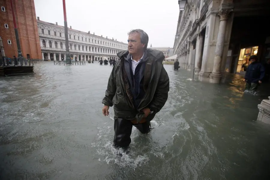 Venice's Mayor Luigi Brugnaro walks in a flooded St. Mark's Square in Venice, Italy, Friday, Nov.15, 2019. The high-water mark hit 187 centimeters (74 inches) late Tuesday, Nov. 12, 2019, meaning more than 85% of the city was flooded. The highest level ever recorded was 194 centimeters (76 inches) during infamous flooding in 1966. (AP Photo/Luca Bruno)